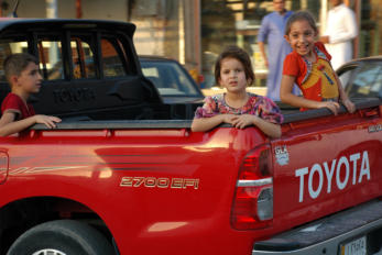 Retrieved photo.  Kids in bed of truck.