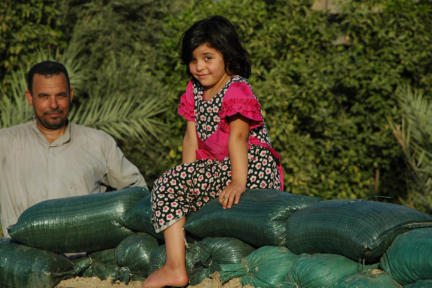 Little girl on sandbags at the home of brothers who fought against ISIS